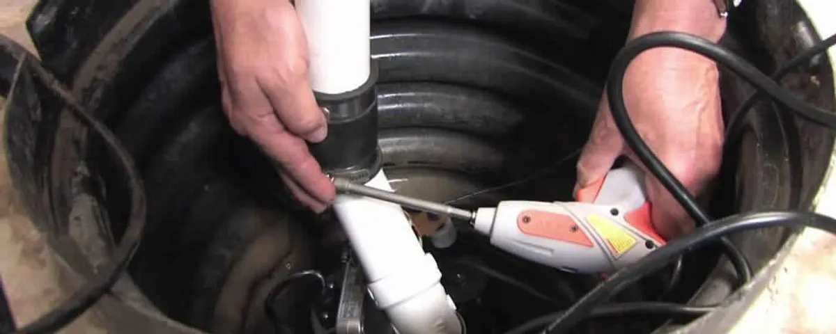 Sump pump installation technician connecting PVC discharge piping in Anaheim, CA